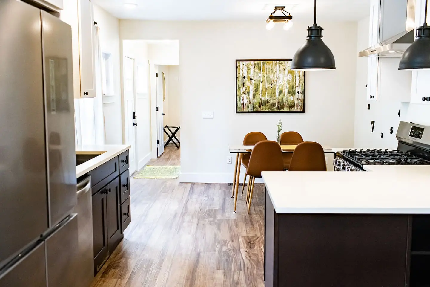 A full kitchen with pendant lights inside one of the rooms
