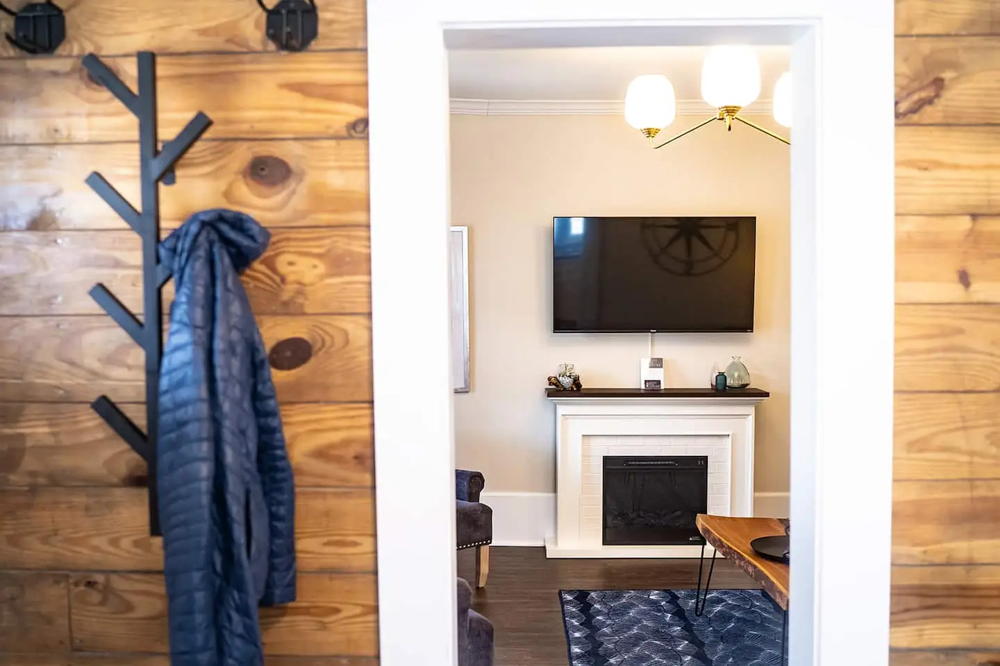 A living room with a wood accent wall and fireplace